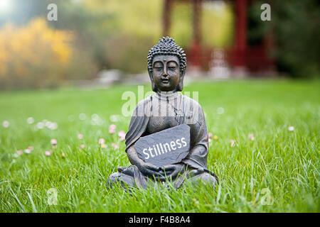 La parola tranquillità con la statua del Buddha Foto Stock