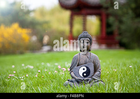 Yin e Yang segno con la statua del Buddha Foto Stock