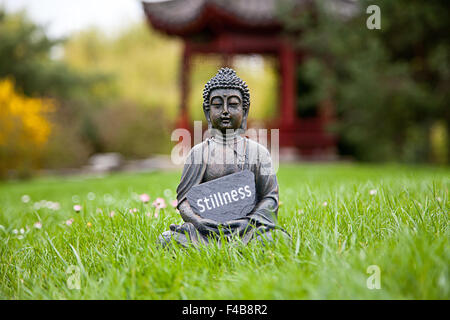 La parola tranquillità con la statua del Buddha Foto Stock