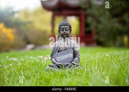 La parola tranquillità con la statua del Buddha Foto Stock