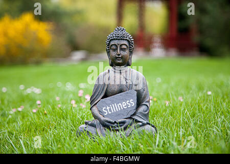 La parola tranquillità con la statua del Buddha Foto Stock