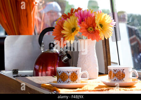 Fiori di seta e tazze vintage all'interno di una Volkswagen camper van Foto Stock