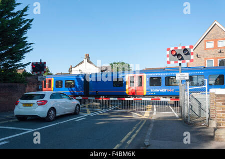 Incrocio ferroviario barriere funzionante a Datchet stazione ferroviaria, High Street, Datchet, Berkshire, Inghilterra, Regno Unito Foto Stock