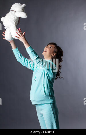 Merry gestante gioca con Teddy bear Foto Stock