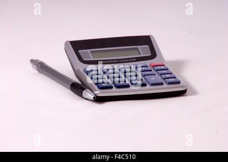 Una calcolatrice e penna isolate su un cyclorama bianco. Foto Stock