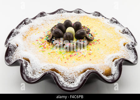 Torta di Pasqua con ripieno di ricotta e cioccolato decorate con uova di cioccolato e di zucchero a velo Foto Stock