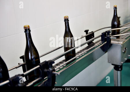 La produzione industriale shot con bottiglie di champagne sul nastro trasportatore in una fabbrica Foto Stock