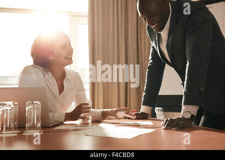 Due giovani uomini di affari che incontro in sala conferenze e lavorando su nuovi progetti. Felice i colleghi per discutere di nuove idee di business. Foto Stock
