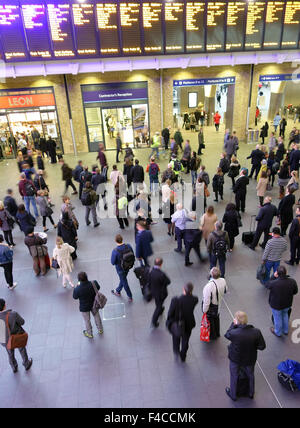 Passeggeri guarda le partenze pensione in Kings Cross stazione ferroviaria, Londra Foto Stock