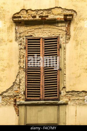La vecchia finestra con blue clappe chiuse su una vecchia casa. Vintage background e texture. Foto Stock