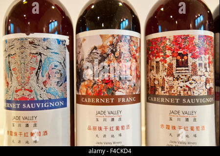 Cina, Shaanxi. Etichette colorate adornano il Cabernet Sauvignon e il cabernet franc bottiglie di vino al Jade Valley Winery e Resort, stabilito di Qingyun Ma nel 2000. Foto Stock