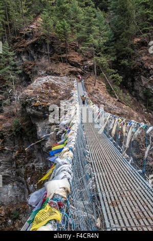 Giovani porter attraversando ponte di sospensione, Nepal. Foto Stock