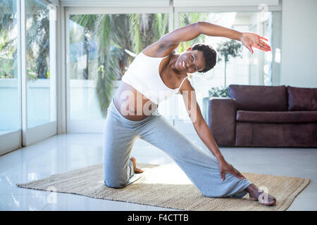 Ritratto di donna incinta stretching mentre ti alleni Foto Stock