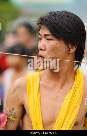 West Kalimantan, Indonesia-February 24, 2013 : Lo sciamano acciai di incollaggio filo nella sua guance. Un supplemento di prestazioni ordinarie di un Foto Stock