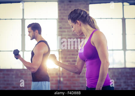 Montare il giovane facendo esercizi con manubri Foto Stock