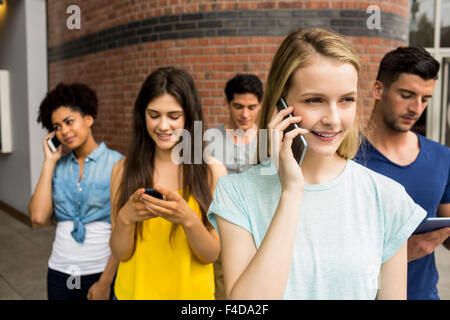 Tutti gli studenti sui loro dispositivi multimediali Foto Stock