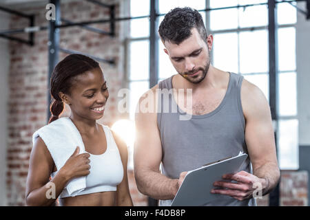 La donna a discutere la sua performance negli appunti con un trainer Foto Stock