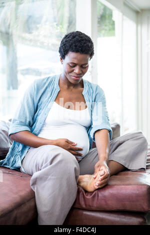 La donna il suo massaggio piedi stanchi Foto Stock