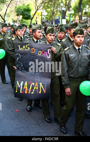 La Paz, Bolivia, 16 ottobre 2015. Un poliziotto porta con sé un cartello con la scritta "droga uccide” durante una marcia attraverso il centro di la Paz, avvertendo dei pericoli derivanti dal consumo di droga. La manifestazione è organizzata ogni anno dalla polizia insieme a scuole e college per educare e sensibilizzare sulla droga e sui suoi pericoli. Crediti: James Brunker / Alamy Live News Foto Stock