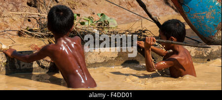 Due ragazzi asiatici giocando nel fango Foto Stock