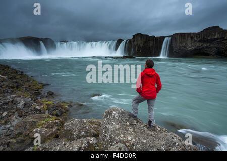 Persona sotto cascate Godafoss, Nordhurland Eystra, Islanda. Foto Stock