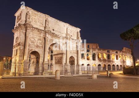 Arco di Costantino e Colosseo illuminata di notte. Roma, Italia Foto Stock