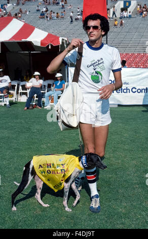 Il famoso disco-la cattura del cane Ashley Whippet prende al campo con il suo proprietario Alex Stein all annuale Frisbee cane World Championship tenutosi presso il Rose Bowl di Pasadena, California, Stati Uniti d'America. L'atletica cane potrebbe correre veloce come 35 miglia all'ora (56 km/h) e leap alta come 9 piedi (2,74 metri) per catturare i dischi volanti nella sua bocca. Ashley ha vinto i primi tre campionati del mondo che ha iniziato nel 1975, e un decennio più tardi il concorso è stato rinominato il Ashley Whippet Invitational in suo onore. Prima che egli morì nel 1985 all'età di 14, il cane eseguito anche nel Super Bowl e la Casa Bianca. Foto Stock