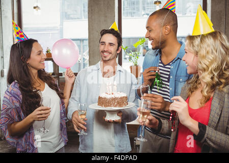 I colleghi holding torta di compleanno e champagne flauti Foto Stock