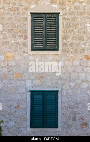 Le vecchie finestre con persiane e muro di pietra nella città vecchia di Dubrovnik, Croazia. Foto Stock