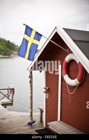 Una rimessa per imbarcazioni da mare con la bandiera svedese. Foto Stock