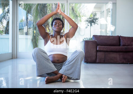 Rilassata donna incinta fare yoga Foto Stock