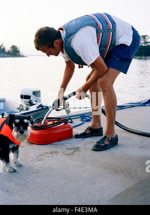 Un uomo refuels una tanica, Sandhamn, Svezia. Foto Stock