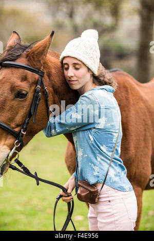 Giovane donna che abbraccia il suo cavallo Foto Stock