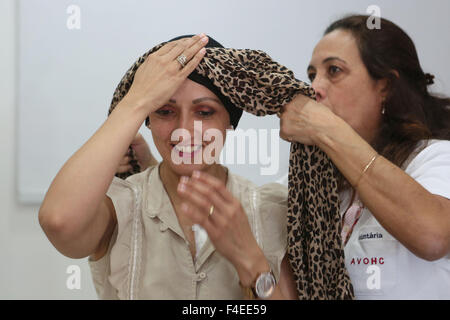 Sao Paulo. 15 ottobre, 2015. Immagine presa sul ott. 15, 2015 mostra Patricia (L), 32 anni, il paziente del Cancer Institute di Sao Paulo Stato, che ha perso i suoi capelli a causa di un trattamento chemioterapico, cercando una nuova sciarpa al centro di volontariato del Cancer Institute di Sao Paulo Stato, in Sao Paulo, Brasile. Il centro di volontariato fornisce gratuitamente le parrucche e sciarpe per donne sottoposte a trattamento di cancro e altri trattamenti di bellezza come manicure e make-up le sessioni con lo scopo di rafforzare la loro autostima e per promuovere il benessere psicologico. © Rahel Patrasso/Xinhua/Alamy Live News Foto Stock