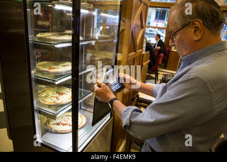 Buenos Aires, Argentina. Xvi oct, 2015. Un uomo prende una foto di pizze con le facce dei candidati presidenziali al 'Los 36 Billares' ristorante pizzeria, nella città di Buenos Aires, Argentina, su 16 Ottobre 2015. Secondo la stampa locale, i proprietari della "Los 36 Billares' ristorante pizza ha deciso di creare la pizza con le immagini dei candidati presidenziali, in occasione delle elezioni che si terranno ad Ottobre 25. © Martin Zabala/Xinhua/Alamy Live News Foto Stock