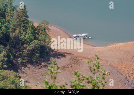 Houseboat parcheggiato in grotta sul Lago Shasta durante la siccità in California mentre incendi sono state bruciando a Mount Shasta. Foto Stock