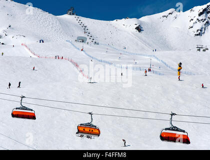 Gli sciatori, seggiovia arancione e corso di slalom in Alpine Ski resort in Solden nelle Alpi Otztal, Tirolo, Austria Foto Stock