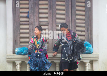 Sapa o sa Pa è una città di frontiera in Vietnam, fotografati qui nella stagione delle piogge e delle piogge, donne della tribù nera degli hmong rifugiate dalla pioggia, Vietnam Foto Stock