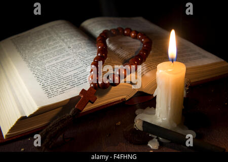 Libro sacro e la croce su un sfondo di legno Foto Stock