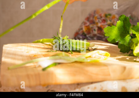 Il prezzemolo e l'aneto sul tagliere di legno. Preparazione di insalata di verdure e ortaggi freschi/insalata fresca con olio d'oliva Foto Stock