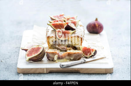 Torta di pane con fichi, mandorle e cioccolato bianco su bianco che serve al di sopra della scheda sfondo grunge, il fuoco selettivo Foto Stock