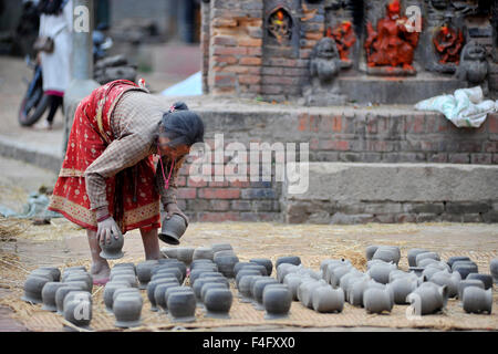 Kathmandu, Nepal. Xvii oct, 2015. Una donna Nepalese organizza il fango vasi in ceramica quadrata in Bhaktapur. Bhaktapur è una città antica nella valle di Kathmandu e viene elencato come un sito del Patrimonio Culturale Mondiale dell UNESCO per la sua ricca cultura, templi e il legno, il metallo e la pietra opere d'arte. © Narayan Maharjan/Pacific Press/Alamy Live News Foto Stock