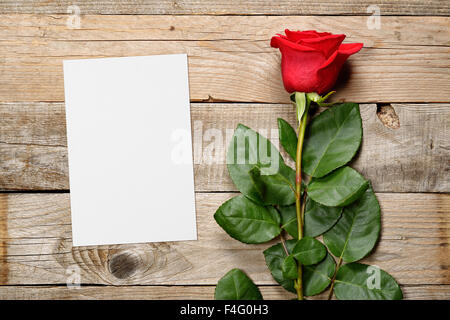 Red Rose e bigliettino vuoto su sfondo di legno Foto Stock