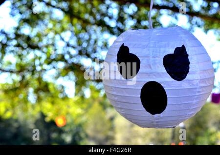Decorazione di Halloween di un volto bianco, ghost, zucca, appeso a un albero. Foto Stock
