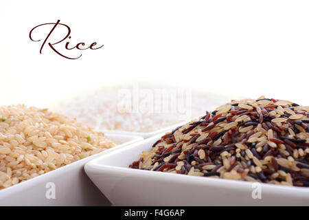 Ciotole quadrate di marrone crudo, bianco e rosso e il riso nero su sfondo bianco con il campione di testo. Foto Stock