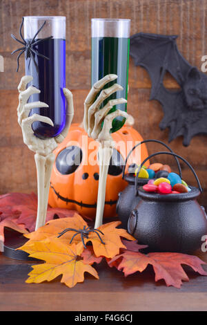 Happy Halloween Zombie Party decorazioni con il verde e il blu delle bevande in mano lo scheletro di occhiali, zucche e candy sulle streghe omento Foto Stock