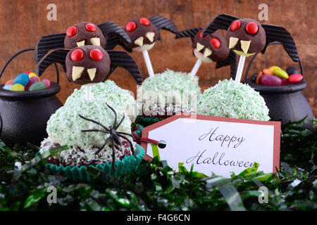 Happy Halloween party i tortini di cioccolato mostruosi lollipop volti e mini liquirizia ala di pipistrello orecchie con la caramella in streghe omento Foto Stock