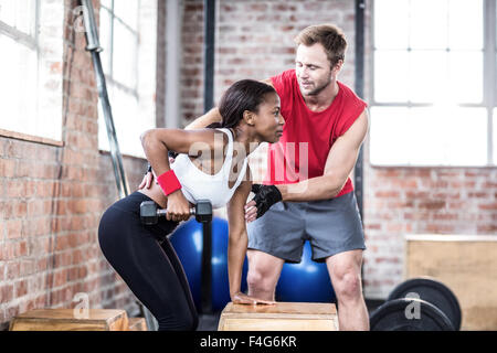 Donna muscolare il sollevamento di pesi con il suo trainer Foto Stock