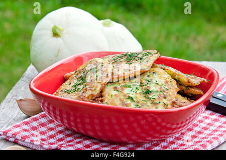 Frittelle di zucchine con aneto su un tavolo di legno. Foto Stock