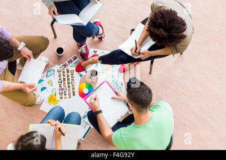 Gli studenti seduti in cerchio lavorando insieme Foto Stock